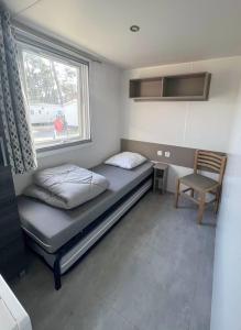 a small room with a bed and a window at SevServices aux Dunes de Contis in Saint-Julien-en-Born