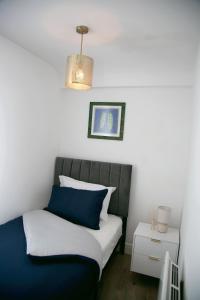 a bedroom with a bed with blue and white pillows at Peace Home in Watford