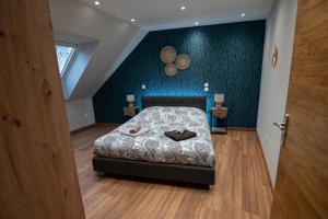 ein Schlafzimmer mit einem Bett und einer blauen Wand in der Unterkunft Gîte Belle Vue in Thannenkirch