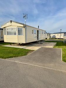 a mobile home parked in a parking lot at Lovely caravan at Martello Beach Holiday Park Sv14 in Jaywick Sands