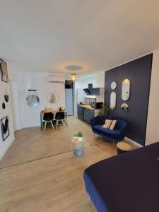 sala de estar con sofá azul y cocina en le Very Cozy en Albi