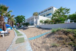 a sandy beach in front of a building at Lido Star Faliraki in Faliraki
