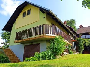 a yellow house with a balcony on the side of it at Holiday House Podhamer Boris with private Wellness in Ljutomer