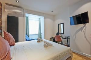 um quarto com uma cama e uma televisão na parede em Hotel Les Ecrins em Bruxelas