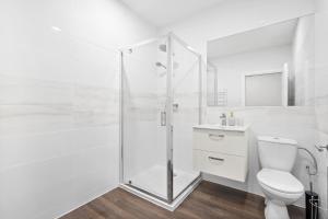 a white bathroom with a shower and a toilet at Leicester Luxury Apartments - Church Gate in Leicester