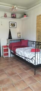 Un dormitorio con una cama con almohadas rojas. en Casa Ceratonia, en Álora