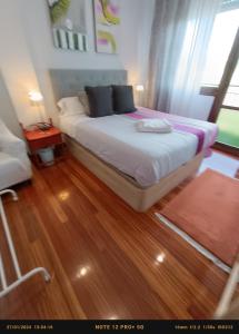 een slaapkamer met een bed en een houten vloer bij Habitación 1 con vistas in Bilbao