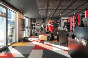 a woman standing at a counter in a clothing store at Hôtel Alhena in Flaine