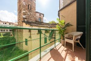 - un balcon avec une chaise et un bâtiment dans l'établissement Historic apt in the center of Lucca with Balcony, à Lucques