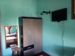 a bedroom with a mirror and a tv on the wall at Hotel da Gaucha in Cruzeiro do Oeste