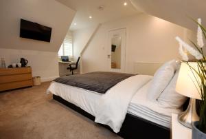 a bedroom with a large bed and a television at Apple Tree Place B&B in Tadley