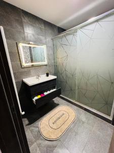 a bathroom with a shower and a sink and a mirror at Standing de luxe, surface de 150 m Paiement uniquement en euros in Oran