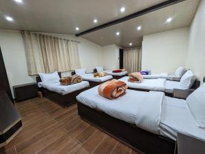 a room with four beds and couches in it at Summer Capital BnB in Shimla