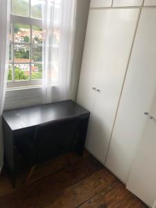 a room with two white cabinets and a window at Casa do Chá Ouro Preto in Ouro Preto