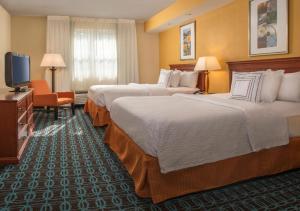 a hotel room with two beds and a flat screen tv at Fairfield Inn & Suites by Marriott Williamsburg in Williamsburg