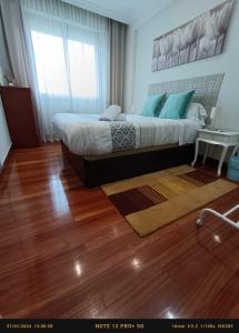 een slaapkamer met een groot bed en een houten vloer bij Habitación 1 con vistas in Bilbao