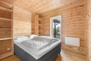 um quarto com uma cama num quarto de madeira em Een gezellig huis in Vrådal met adembenemend uitzicht em Vradal