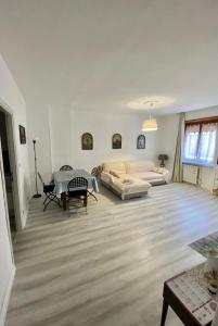 a living room with a couch and a table at Appartamento Lella zona Terme Centro e vicino Villa Igea sito in Via Emilia 29 in Acqui Terme