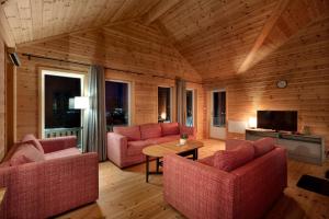 uma sala de estar com duas cadeiras cor-de-rosa e uma mesa em Een gezellig huis in Vrådal met adembenemend uitzicht em Vradal