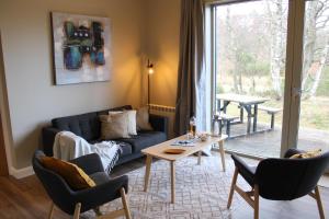 a living room with a couch and a table at Betula Chalet – coast & country in the Highlands in Nairn