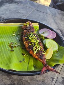 a plate of food with fish on a green leaf at SEA WALK Serenity beachside in Puducherry