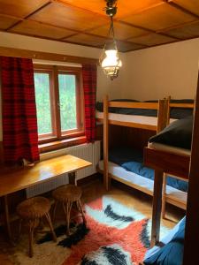 a bedroom with two bunk beds and a table and chairs at Chata u Lucky in Liptovský Mikuláš