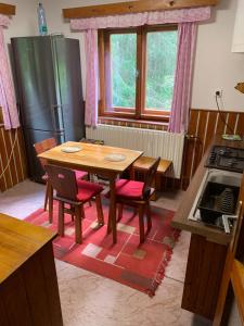 a kitchen with a wooden table and chairs and a stove at Chata u Lucky in Liptovský Mikuláš +25 photos