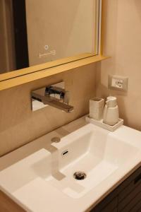 La salle de bains est pourvue d'un lavabo blanc et d'un miroir. dans l'établissement Garden by Holistay, à Tirana
