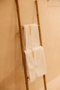 a towel rack with two white towels on it at Garden by Holistay in Tirana