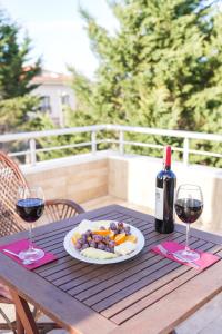 ein Tisch mit einem Teller Essen und einer Flasche Wein in der Unterkunft BUTTERFLY BOUTIQUE HOTEL AĞVA in Sile