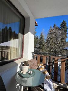 a small table on a balcony with a window at Arboro Borovets Gardens E43 in Borovets