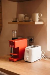 a red coffee maker and a toaster on a counter at Garden by Holistay in Tirana