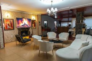 a living room with white chairs and a fireplace at Destina Hotel Agva in Şile