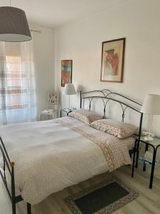 - une chambre avec un grand lit et deux lampes dans l'établissement Appartamento Lella zona Terme Centro e vicino Villa Igea sito in Via Emilia 29, à Acqui Terme
