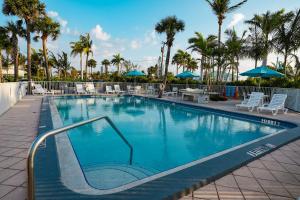 a large swimming pool with chairs and umbrellas at Manasota Key Resort in Englewood