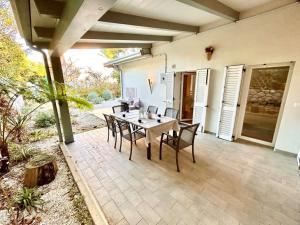 a patio with a table and chairs on it at Villa Mathilde, deliziosa villetta con spiaggia inclusa in Numana