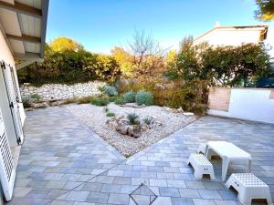 a patio with two benches and a garden at Villa Mathilde, deliziosa villetta con spiaggia inclusa in Numana +17 photos