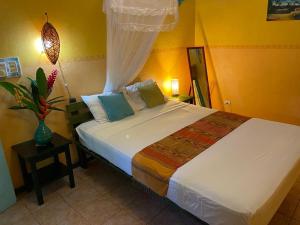 1 dormitorio con 1 cama grande en una habitación en Cabinas Guarana, en Puerto Viejo