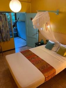 a bedroom with a large white bed in a room at Cabinas Guarana in Puerto Viejo