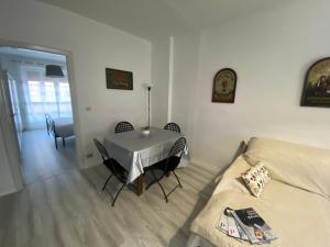 salon ze stołem i kanapą w obiekcie Appartamento Lella zona Terme Centro e vicino Villa Igea sito in Via Emilia 29 w mieście Acqui Terme