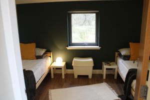 a small room with two beds and a window at Betula Chalet – coast & country in the Highlands in Nairn +22 photos