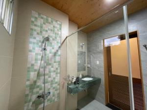 a bathroom with a sink and a shower at 飲山風民宿 in Ji'an