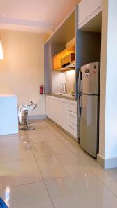 a kitchen with a stainless steel refrigerator and white cabinets at Cozy Stay at Shaftsbury Residences by SNS HOMES in Cyberjaya