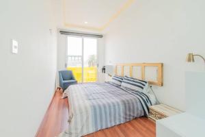 een witte slaapkamer met een bed en een blauwe stoel bij LOFT ULTRA Moderno y Minimalista con 2 Camas KING Size in Durango