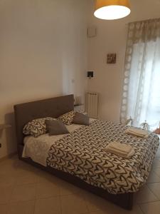 a bedroom with a bed with a black and white comforter at Brunelleschi House with garden in Fiumicino