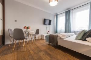 a bedroom with a bed and a table and chairs at Chmielna Apartments Warsaw Center in Warsaw