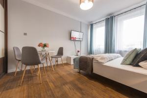a bedroom with a bed and a table and chairs at Chmielna Apartments Warsaw Center in Warsaw