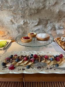 a table with a plate of food with fruit on it at Bnb Verdeolivo in Coriano