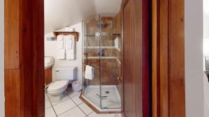 La salle de bains est pourvue de toilettes et d'une douche en verre. dans l'établissement Auberge Spa & Beaux Reves, à Sainte-Adèle