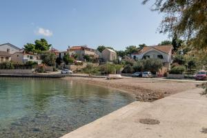 un cuerpo de agua con casas al fondo en Apartment Natasa, en Rogoznica